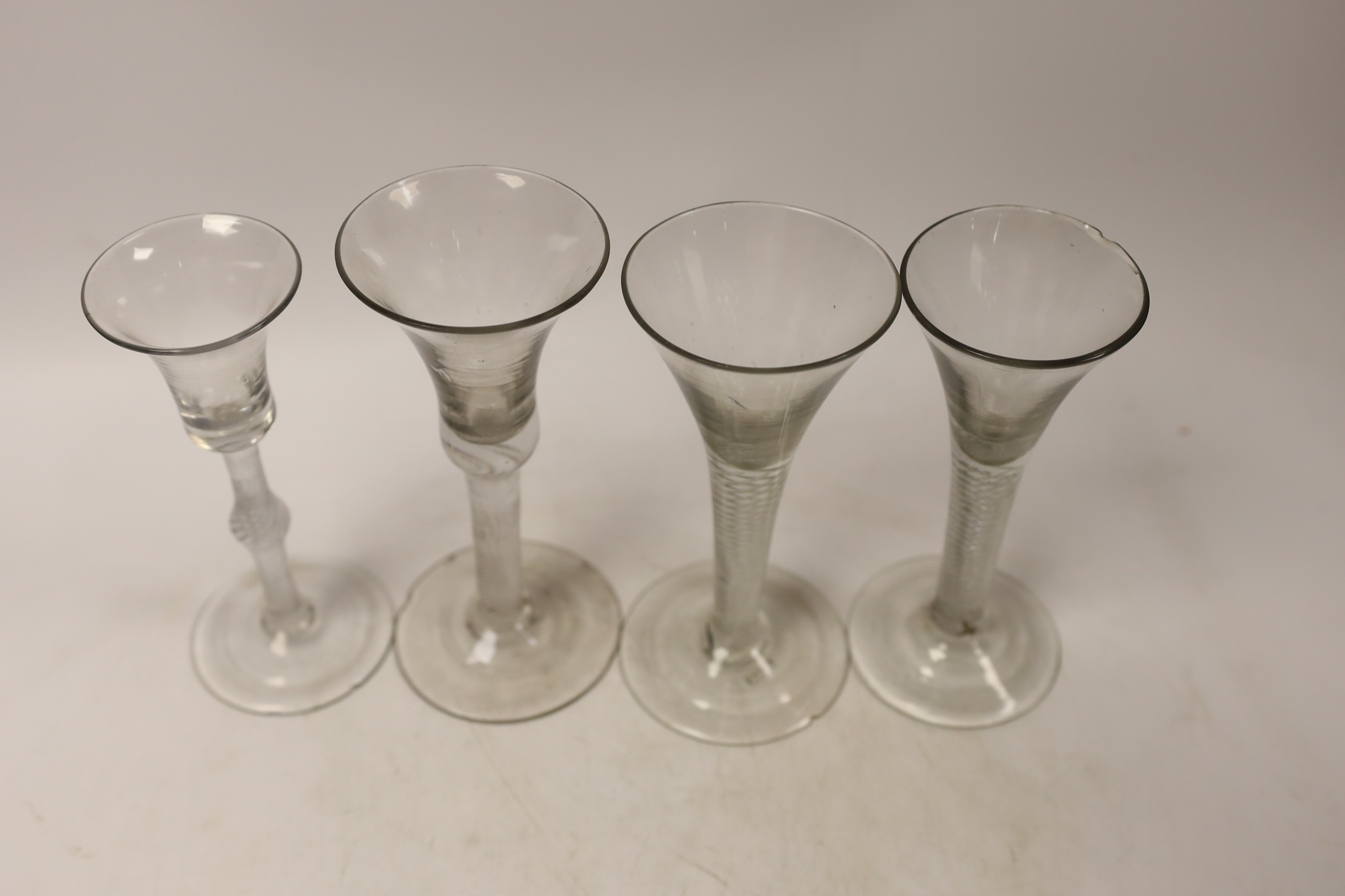 Four mid-18th century DSAT stem wine glasses, two drawn trumpet examples and two with bell shaped bowls, tallest 15.5cm